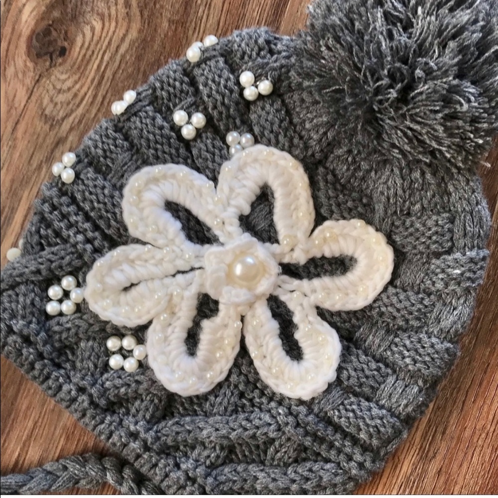 Cable knit hat with appliqué.